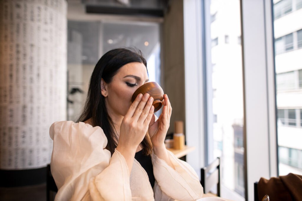 Woman sipping bone broth for the health and beauty benefits of collagen
